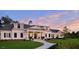 Elegant home with lush green lawn, symmetrical design, and a horseshoe driveway at 100 Emory Bluffs Dr, Holly Springs, NC 27540