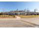 Expansive single-Gathering home featuring manicured lawns, mature trees, and circular driveway at 100 Emory Bluffs Dr, Holly Springs, NC 27540