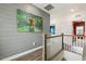 Hallway features light wood floors, gray walls, and colorful dog art at 100 Emory Bluffs Dr, Holly Springs, NC 27540