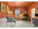 Cozy home office with modern desk, sofa, and burnt orange walls at 100 Emory Bluffs Dr, Holly Springs, NC 27540