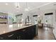View of kitchen island with seating, open to the dining and living areas at 100 Emory Bluffs Dr, Holly Springs, NC 27540