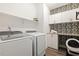 Efficient laundry room with modern appliances, ample storage, and stylish wallpaper at 100 Emory Bluffs Dr, Holly Springs, NC 27540