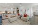 Open-concept living room with modern decor, neutral colors, and a view into the kitchen at 100 Emory Bluffs Dr, Holly Springs, NC 27540