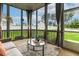 Relaxing screened porch with comfortable seating, airy curtains, and view of the fenced backyard at 100 Emory Bluffs Dr, Holly Springs, NC 27540