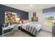 Cozy bedroom with a blue accent wall, stylish desk, and natural light at 100 Reagan Crest Dr, Clayton, NC 27520