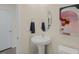 A charming powder room featuring a pedestal sink, decorative mirror, and modern artwork at 100 Reagan Crest Dr, Clayton, NC 27520