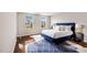 A bright bedroom with hardwood floors and a blue upholstered bed at 1004 Summer Mist Ln, Durham, NC 27704