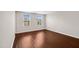 Empty bedroom with hardwood floors and two windows that provide natural light at 1004 Summer Mist Ln, Durham, NC 27704