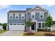 Charming two-story home featuring a two-car garage, black door, and well-manicured front yard at 1004 Summer Mist Ln, Durham, NC 27704