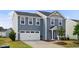 Inviting two-story home with a two-car garage, classic blue siding, and lush landscaping at 1004 Summer Mist Ln, Durham, NC 27704