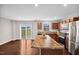 Well-lit kitchen with center island, stainless steel appliances, wood cabinets and sliding glass door at 1004 Summer Mist Ln, Durham, NC 27704