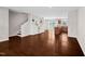 Open-concept living room with hardwood floors, built-in shelving, and stairs to the second level at 1004 Summer Mist Ln, Durham, NC 27704