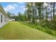 An exterior view of a large grassy backyard with trees in the distance at 107 Altair Ln, Sanford, NC 27330
