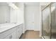 Bathroom with double sinks, granite countertops, and a glass-enclosed shower with a built-in seat at 107 Altair Ln, Sanford, NC 27330