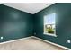 Empty bedroom painted with dark green paint, carpeted floors and a window at 107 Altair Ln, Sanford, NC 27330