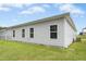 Side view of home exterior showing vinyl siding, multiple windows, green lawn, and partial blue sky at 107 Altair Ln, Sanford, NC 27330