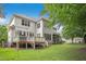 Two-story home featuring a wooden deck that overlooks a green and open backyard at 10909 Grand Journey Ave, Raleigh, NC 27614