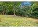 Well-maintained backyard with a grassy lawn and mature trees, offering privacy at 10909 Grand Journey Ave, Raleigh, NC 27614