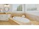 Bright bathroom features a soaking tub with tile surround, granite counters, and modern fixtures at 10909 Grand Journey Ave, Raleigh, NC 27614