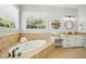Bright bathroom features a soaking tub with tile surround, granite counters, and modern fixtures at 10909 Grand Journey Ave, Raleigh, NC 27614
