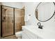 Modern bathroom features a glass-enclosed shower and a stylish vanity with a round mirror at 10909 Grand Journey Ave, Raleigh, NC 27614
