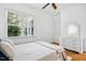 Bright bedroom featuring a window, a ceiling fan, and a classic white dresser with a decorative mirror at 10909 Grand Journey Ave, Raleigh, NC 27614