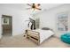 Bright bedroom with a wooden bed frame, ceiling fan, and window offering natural light at 10909 Grand Journey Ave, Raleigh, NC 27614