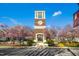 Bedford community clock tower with brick base, white trim, Roman numerals, and spring trees around the landscaped entrance at 10909 Grand Journey Ave, Raleigh, NC 27614