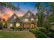 Beautiful two-story home featuring stone accents, manicured landscaping and inviting entrance at sunset at 10909 Grand Journey Ave, Raleigh, NC 27614