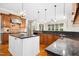 The open concept kitchen features wood cabinets, granite countertops, and stainless steel appliances at 10909 Grand Journey Ave, Raleigh, NC 27614
