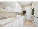 Well-equipped laundry room with ample storage cabinets, sink, and modern washer and dryer at 10909 Grand Journey Ave, Raleigh, NC 27614