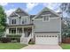 Charming two-story home with a welcoming front porch, manicured lawn and attached two car garage at 1138 Bexley Hills Bnd, Apex, NC 27502