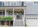 Inviting front porch with white railing and stairs leading to a stylish, wood-framed front door at 1138 Bexley Hills Bnd, Apex, NC 27502