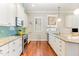 Bright kitchen with granite countertops, stainless steel appliances, and custom shelving at 1138 Bexley Hills Bnd, Apex, NC 27502