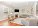 Bright living room featuring hardwood floors, a cozy fireplace, and a comfortable, gray sectional sofa at 1138 Bexley Hills Bnd, Apex, NC 27502
