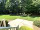 View from the porch steps to backyard with mature trees, plush grass and landscaping at 122 Barringer Dr, Garner, NC 27529