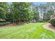 Expansive green backyard with lush landscaping and mature trees stretches far beyond the home at 122 Barringer Dr, Garner, NC 27529