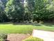 Well-maintained backyard with plush green grass, lush trees and landscaping at 122 Barringer Dr, Garner, NC 27529