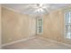 Neutral bedroom features a ceiling fan, a large window, and plush carpeting, offering a bright living space at 122 Barringer Dr, Garner, NC 27529