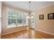 Sunlit breakfast nook features hardwood floors, classic chandelier, and bright windows with peaceful views at 122 Barringer Dr, Garner, NC 27529