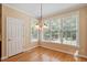 Sunlit breakfast nook features hardwood floors, classic chandelier, and bright windows with peaceful views at 122 Barringer Dr, Garner, NC 27529