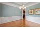 Dining room featuring hardwood floors, wainscoting, and a modern chandelier at 122 Barringer Dr, Garner, NC 27529