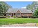 Charming brick home with pristine lawn and landscaping and covered porch for relaxing at 122 Barringer Dr, Garner, NC 27529