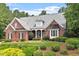 Traditional brick home featuring a well-maintained lawn, mature trees, and inviting front entrance at 122 Barringer Dr, Garner, NC 27529