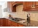 Kitchen with granite countertops, wooden cabinetry, and a tile backsplash provides plenty of space for cooking at 122 Barringer Dr, Garner, NC 27529