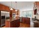 Well-appointed kitchen with stainless steel appliances, a center island, custom cabinetry, and hardwood flooring at 122 Barringer Dr, Garner, NC 27529