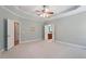 Spacious primary bedroom with tray ceiling, neutral carpeting, and bright windows offering natural light at 122 Barringer Dr, Garner, NC 27529