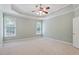 Spacious primary bedroom with tray ceiling, neutral carpeting, and bright windows offering natural light at 122 Barringer Dr, Garner, NC 27529