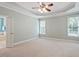Spacious primary bedroom with tray ceiling, neutral carpeting, and bright windows offering natural light at 122 Barringer Dr, Garner, NC 27529