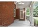 Charming covered porch with brick exterior and a view of the surrounding greenery at 122 Barringer Dr, Garner, NC 27529